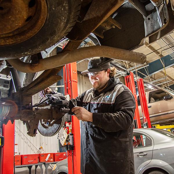 A man working on a car on a lift