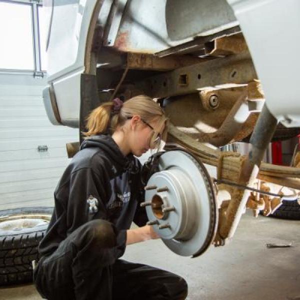 A VIU automotive apprentice student is inspecting a vehicle