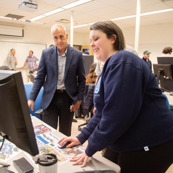 A VIU ITAS student shows a guest to the ITAS Project Fair their final project.