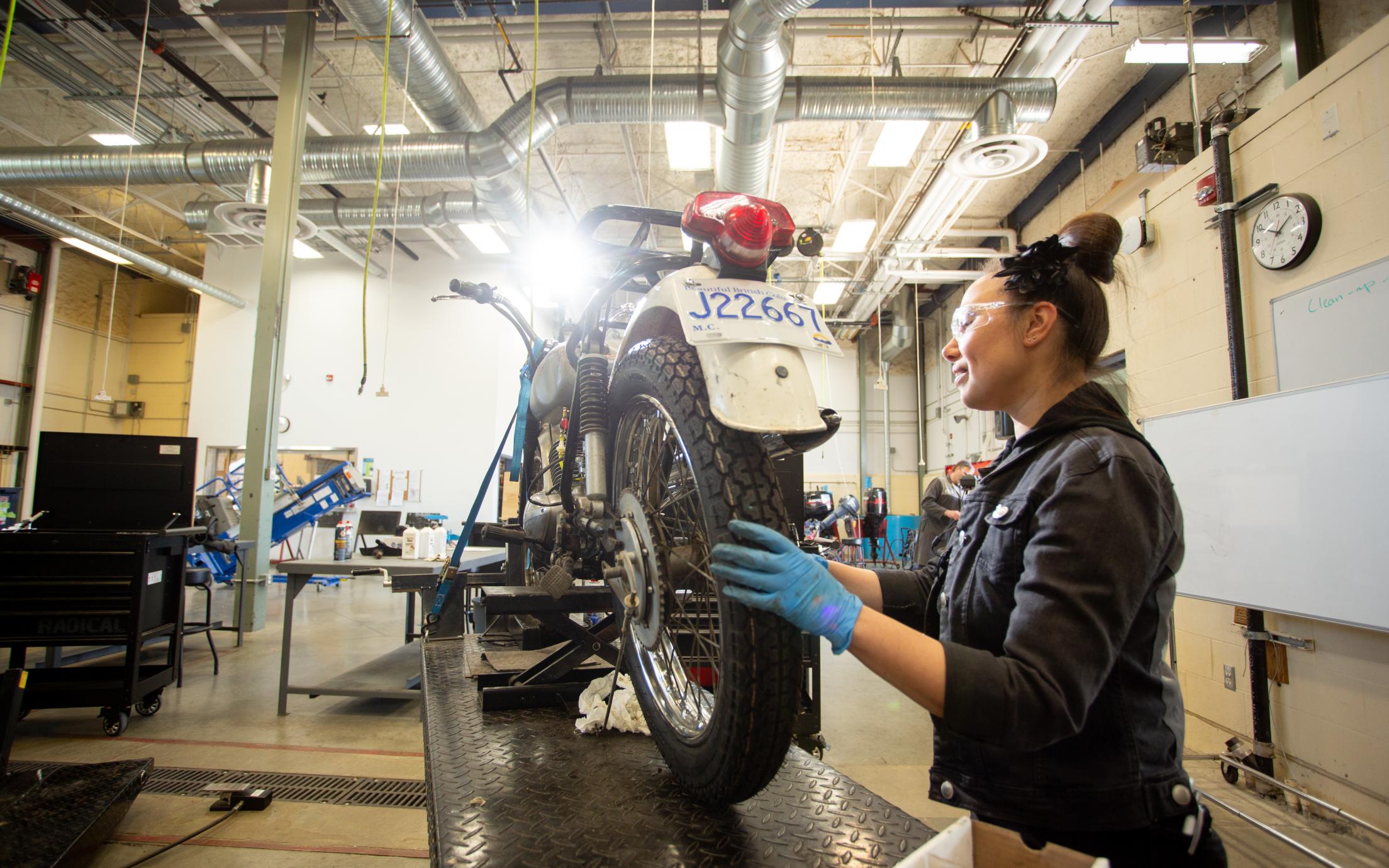 A VIU Motorcycle and Marine Technician stduent works on a motorbike