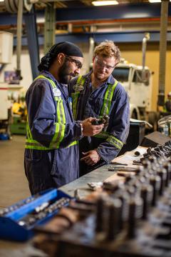 Two young men working in a mechanical shop.