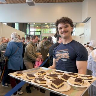 A viu baking alumni holds out a tray of Nanaimo bar pieces