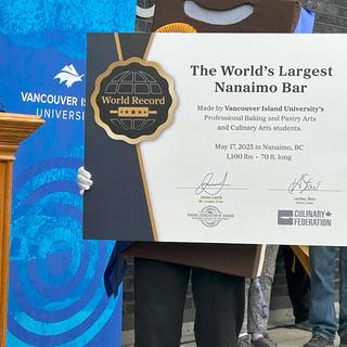 Nanai the Nanaimo bar mascot holds the official world record certificate