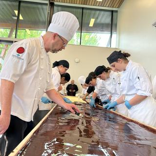 VIU baking students apply the chocolate layer to the  world's largest Nanaimo bar