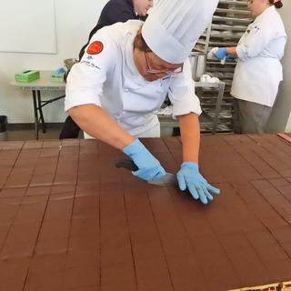 A VIU culinary program instructor cuts the Nanaimo bar.