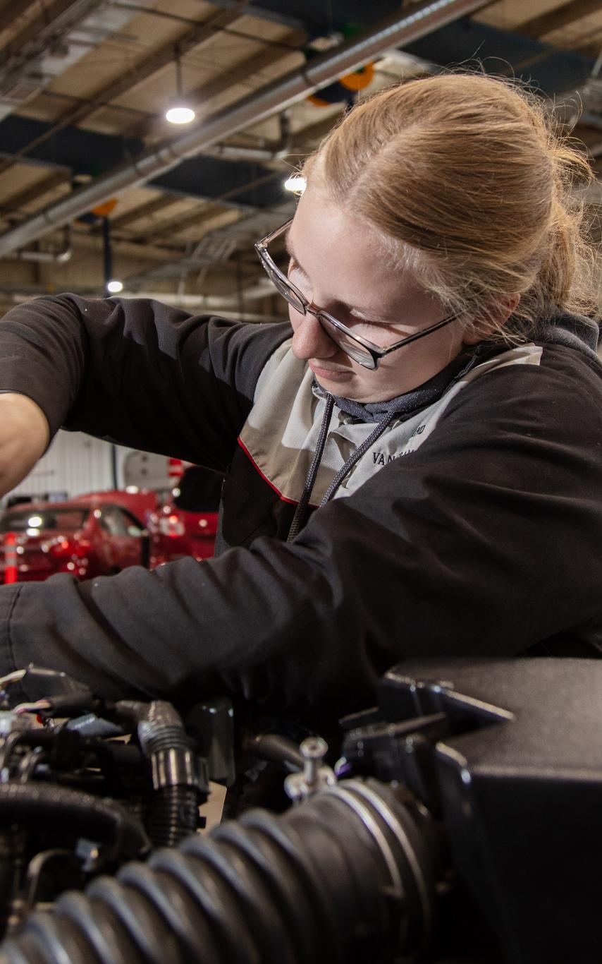 an auto student fixes a car engine
